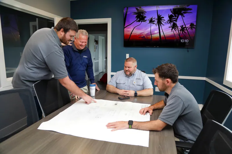 Shorite Controls and Process Integration, Inc. staff reviewing a panel drawing around a table