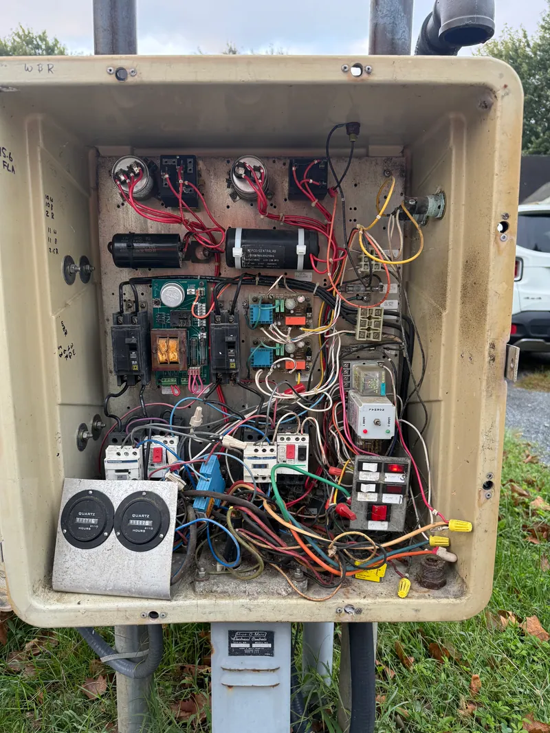 Before: an aging outdoor field panel — a weathered enclosure with tangled, mixed wiring and add-on components